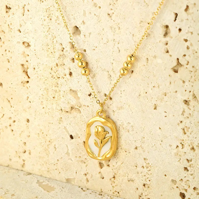 18k gold plated stainless steel necklace featuring a gold-toned oval pendant with a delicate tulip design and small gold beads along the chain.