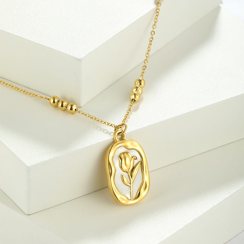 18k gold plated stainless steel necklace featuring an oval pendant with a delicate tulip shell design and small spherical bead accents on the chain.