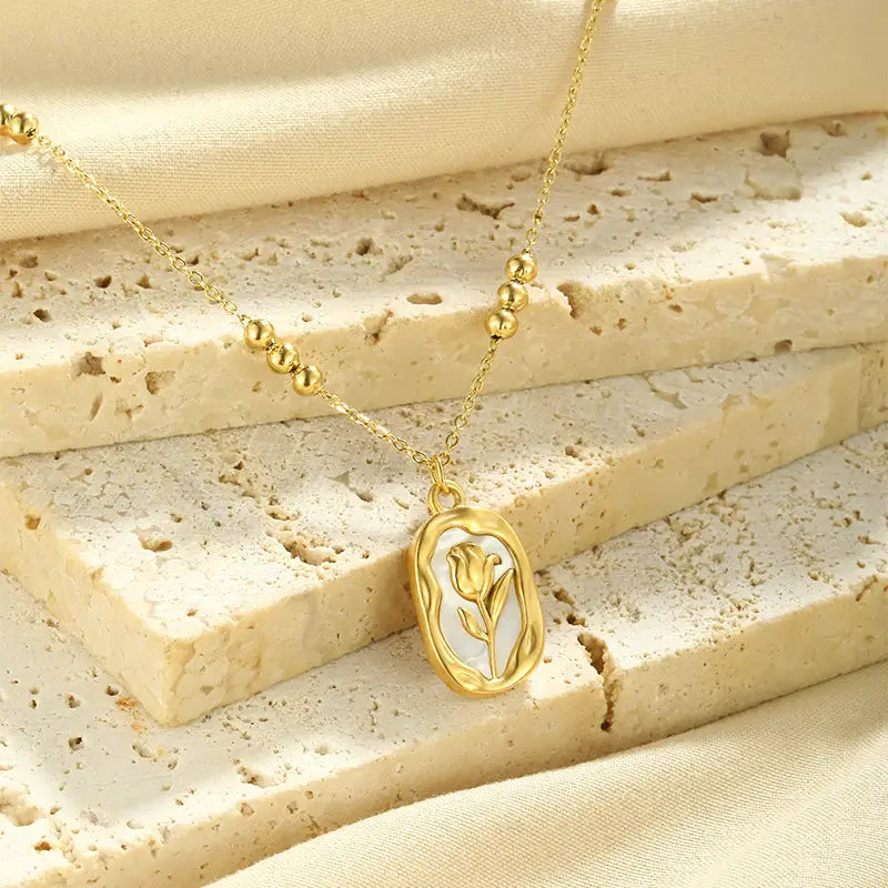 18k gold plated stainless steel tulip shell pendant necklace with a gold-toned tulip pendant, delicate chain, and small spherical beads.