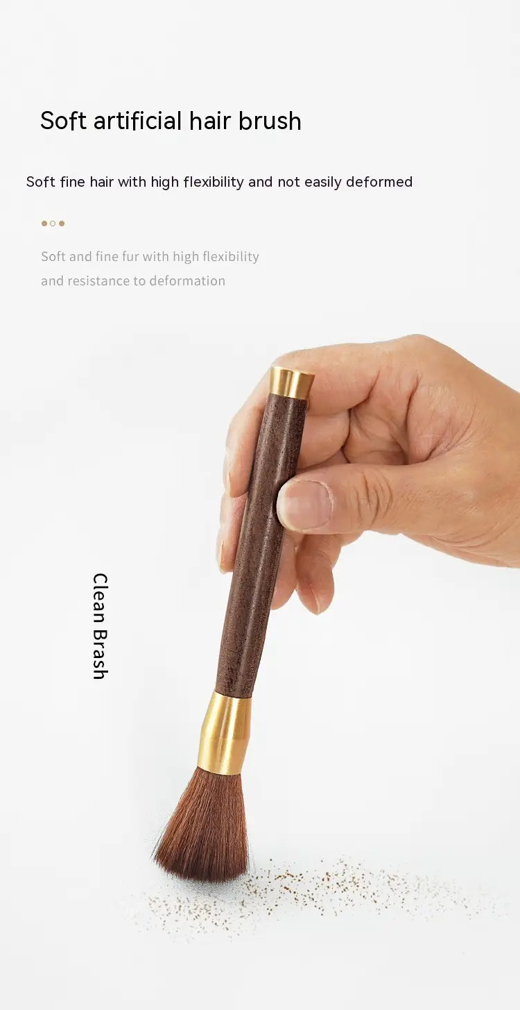A sleek dark brown wooden-handled coffee grinder cleaning brush with gold-toned brass accents and soft fine bristles.