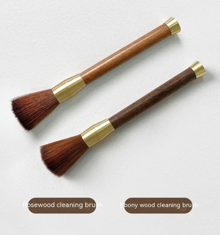 Two elegant coffee grinder cleaning brushes with wooden handles made of rosewood and ebony, featuring brass accents and dense dark brown bristles.