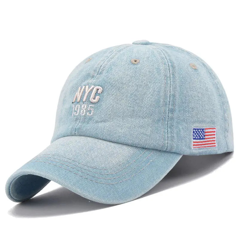 Men denim nyc baseball cap in light blue with nyc 1985 embroidered in white and a small American flag patch on the side.