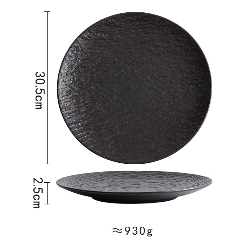Black ceramic round plate with a textured stone-like surface and a slightly raised rim featuring a Nordic rock pattern.