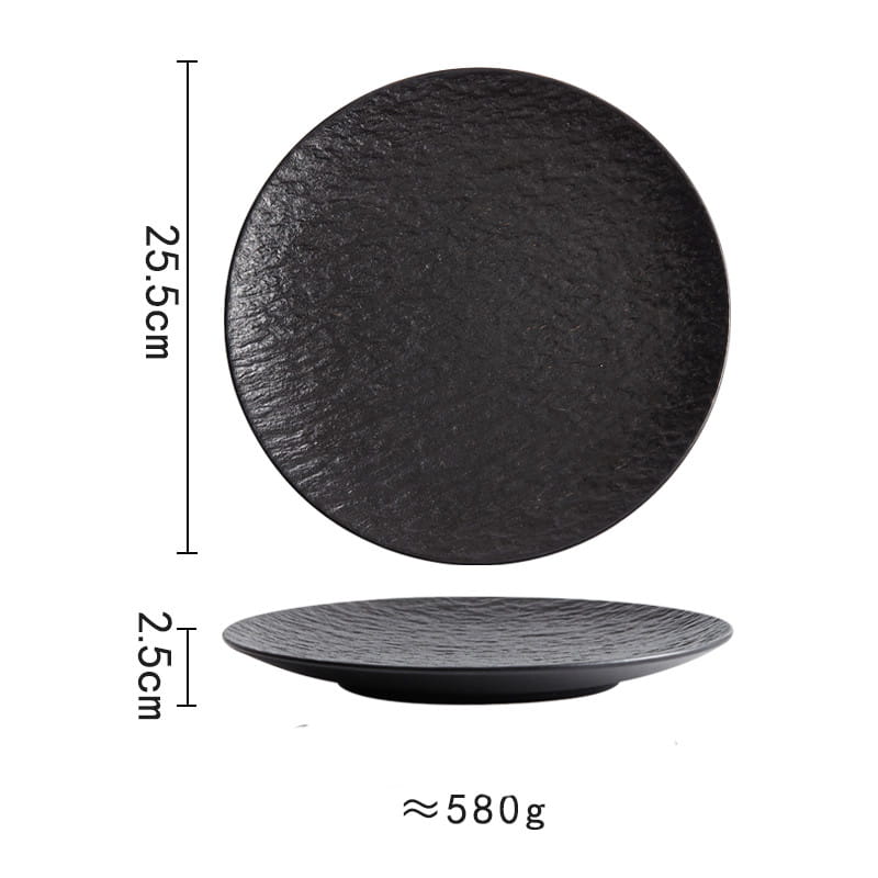 Black ceramic round plate with a textured stone-like surface and slightly raised rim featuring a Nordic rock pattern.