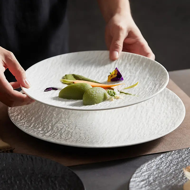 white ceramic round plates with a textured hammered finish featuring a nordic rock pattern design