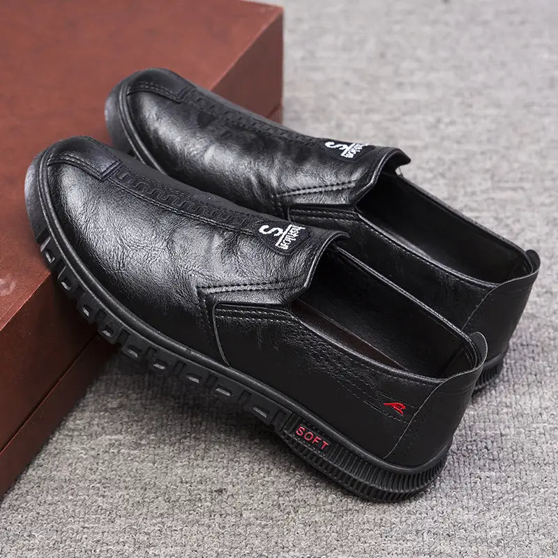 Chaussures de chef noires en cuir, à enfiler, avec des semelles antidérapantes texturées et des détails de marquage discrets, conçues pour un usage de travail imperméable.