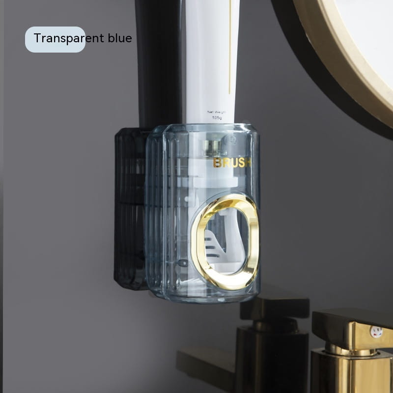 Transparent blue automatic toothpaste dispenser and toothbrush holder with a gold-colored circular accent and black mounting bracket.