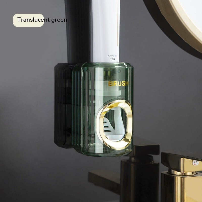 translucent green automatic toothpaste dispenser and toothbrush holder with gold-accented circular opening and vertical ridges.