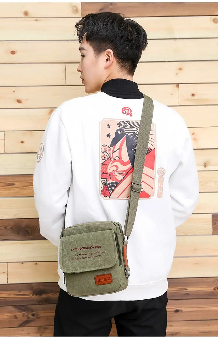 Men’s olive green canvas crossbody business shoulder bag with brown leather accents and a front flap pocket.