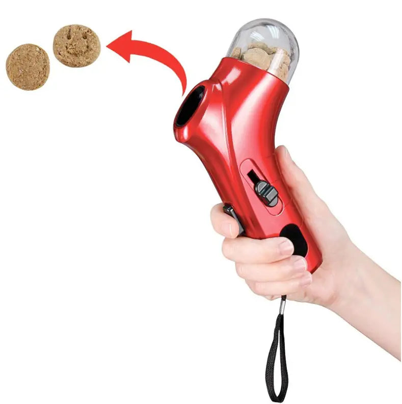broyeur de bouchons à main rouge, avec dôme supérieur transparent et accents de prise noirs, utilisé comme cliquet d’entraînement pour animaux de compagnie et distributeur de friandises.