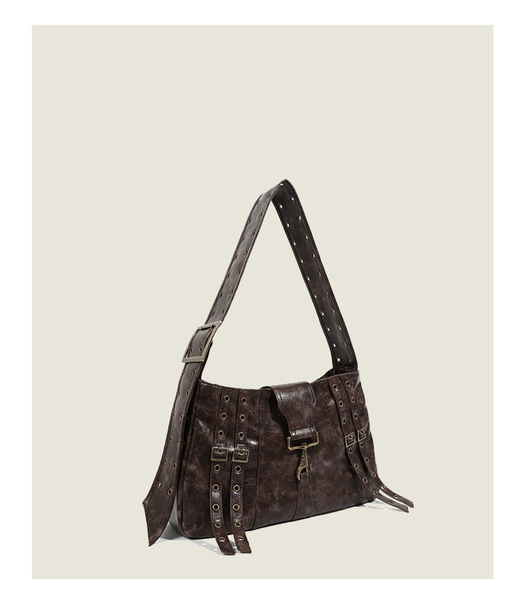 Brown leather punk crossbody bag with distressed texture metal buckles and eyelets along the straps.