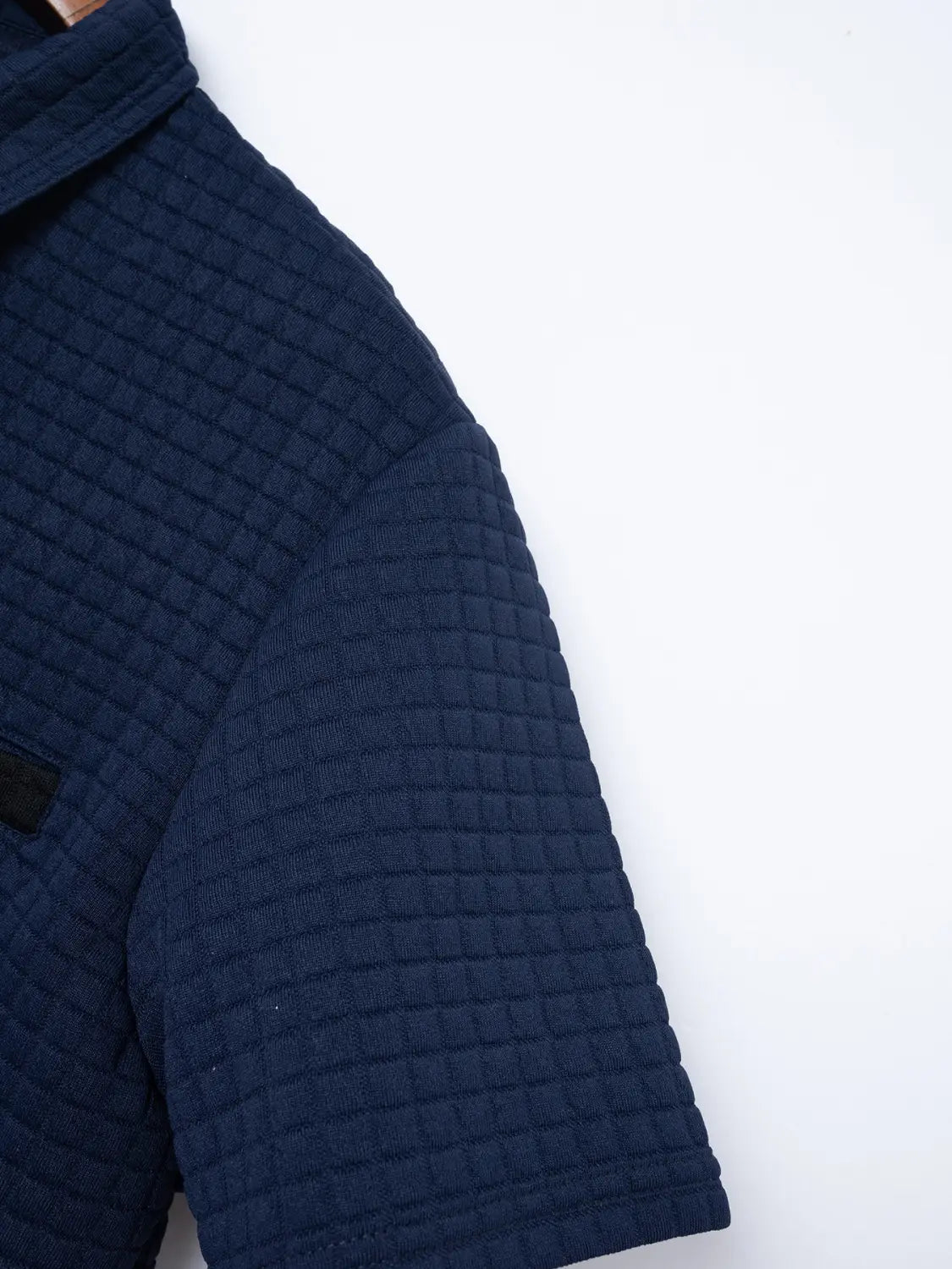 Herren-Navyblaues, wattiertes Jacquard-Karree-Sportpolohemd mit kurzen Ärmeln, mit Kragen und Kontrastbesatz.