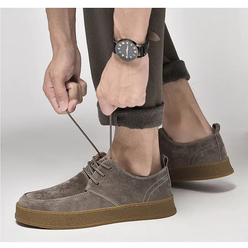 Chaussures plates décontractées à lacets en daim gris pour hommes, avec une semelle en caoutchouc couleur tan.