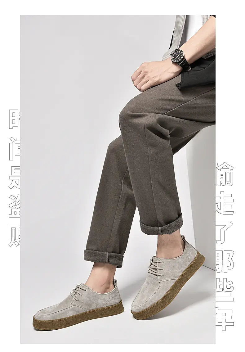Chaussures plates décontractées à lacets en daim gris pour hommes, avec une semelle en caoutchouc marron contrastante.