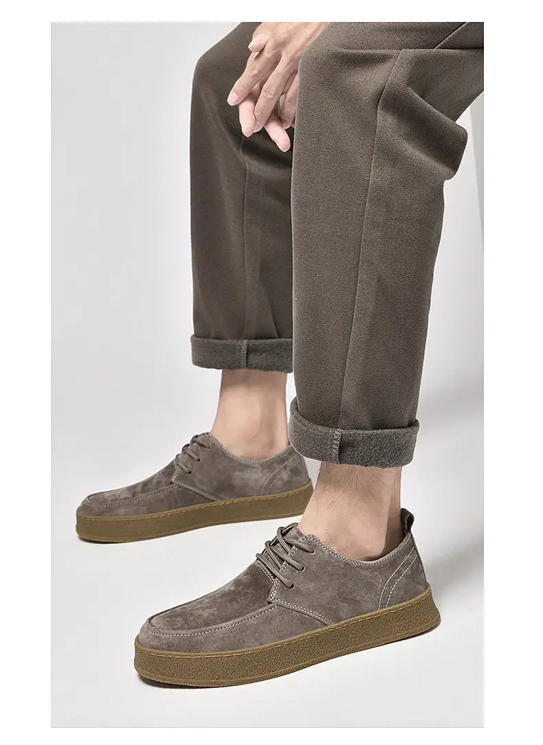 Chaussures plates décontractées à lacets en daim gris pour hommes, avec une semelle en caoutchouc couleur tan.