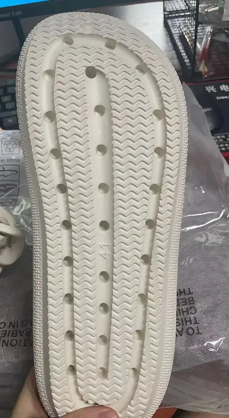 white rubber sole with a textured wavy pattern and circular indentations on men lightweight mesh clog slippers with adjustable straps