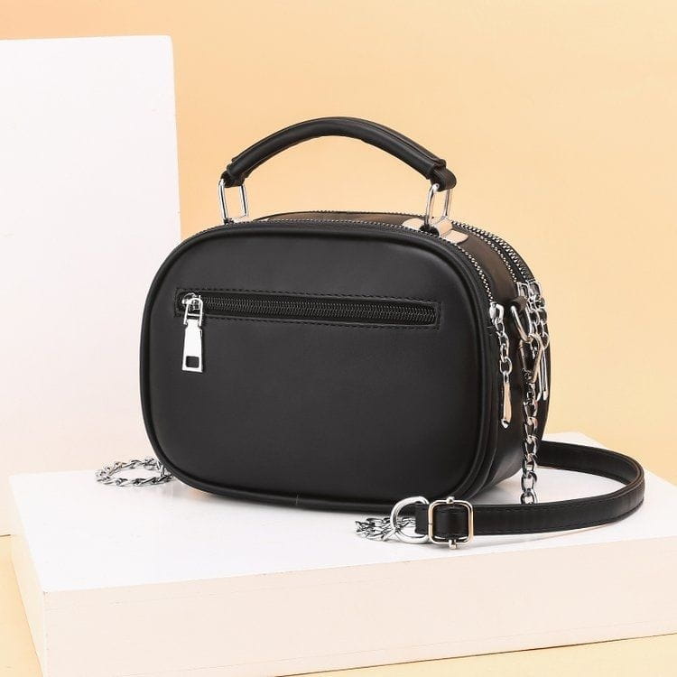 Black quilted faux leather camera-style crossbody handbag with silver-toned hardware and chain strap.