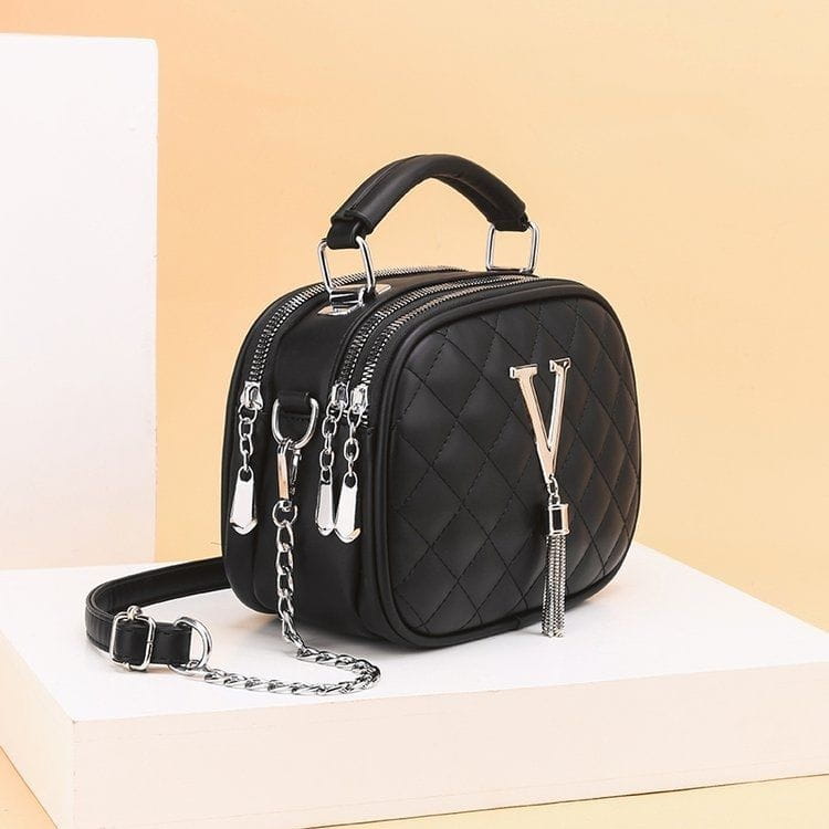 Black quilted handbag with silver tone v zipper pull and chain strap featuring silver hardware.