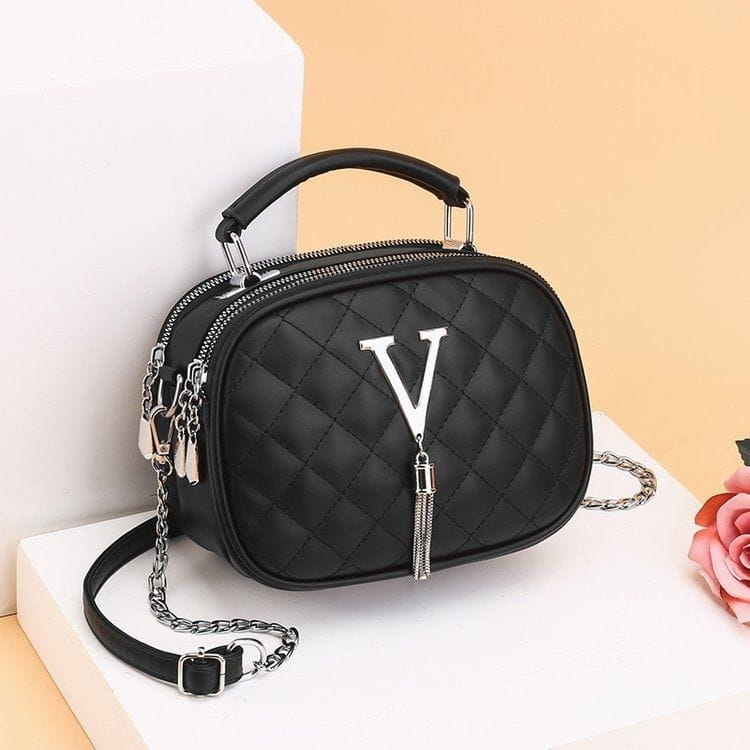 Black quilted handbag with silver v zipper pull and chain strap featuring silver hardware for elegant style.