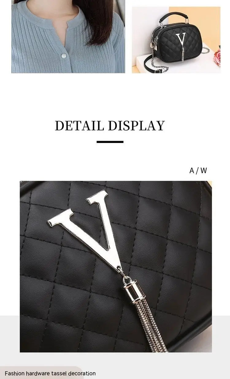 Black quilted handbag with silver v hardware tassel decoration and chain strap made of silver hardware.