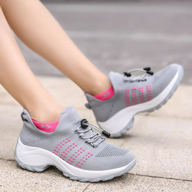 women’s lightweight fly knit casual sneakers in gray knit with pink accents and black lacing toggles