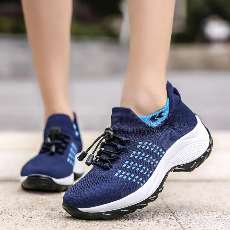 Navy blue lightweight fly knit casual sneakers for women featuring light blue accents and a white midsole.