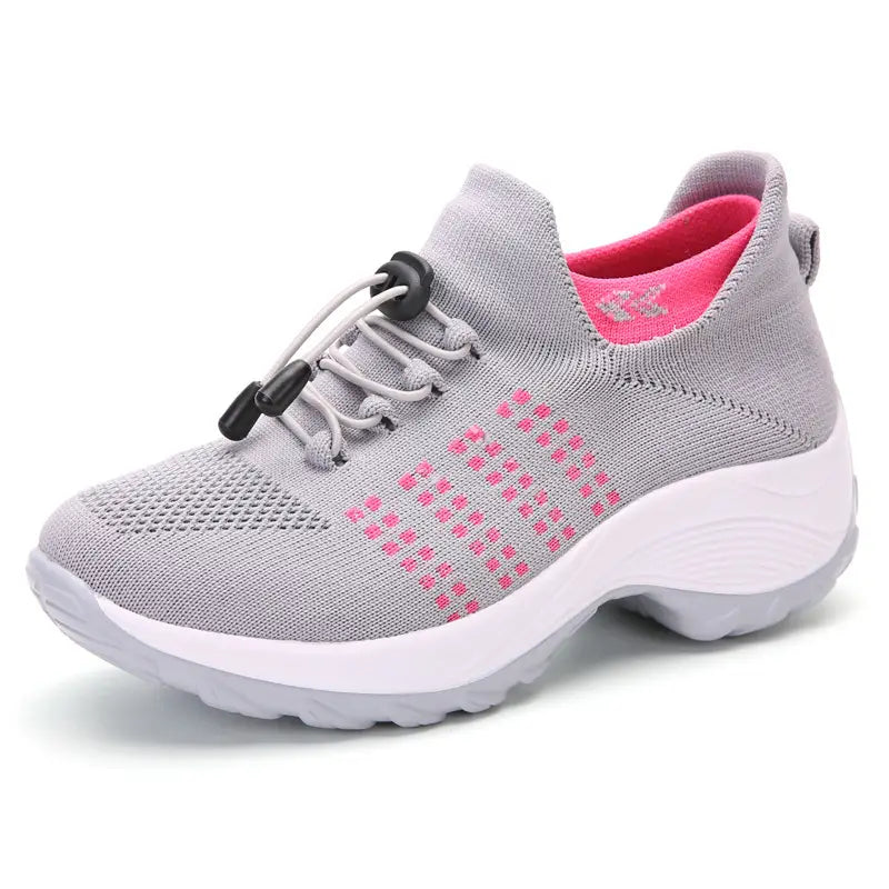 women’s lightweight fly knit casual sneaker in gray with pink accents and a white rubber sole made from knit material for comfortable everyday wear