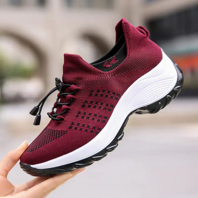 Women’s lightweight fly knit casual sneakers in maroon with black laces and a white midsole displayed from the front.