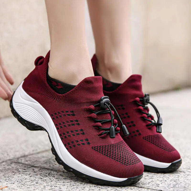 Women’s lightweight fly knit casual sneakers in maroon with black laces and a white midsole.