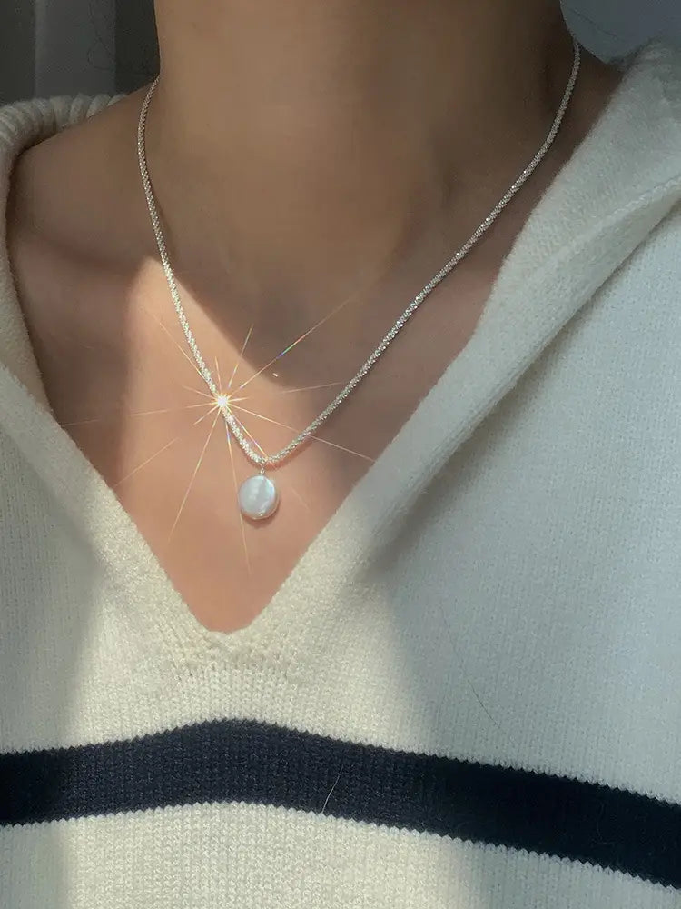 A sterling silver chain necklace featuring a single smooth white baroque pearl pendant from the starry sky collection.