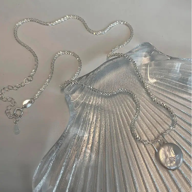 Sterling silver chain necklace featuring a round iridescent baroque pearl pendant inspired by the starry sky.