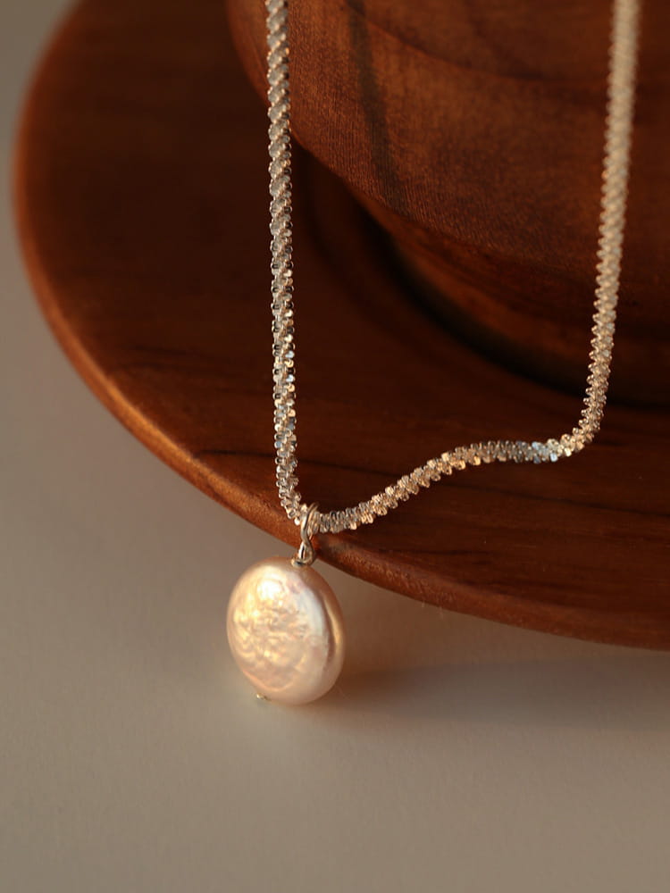 Sterling silver baroque pearl starry sky necklace featuring a delicate silver chain and a single lustrous off-white freshwater pearl pendant.