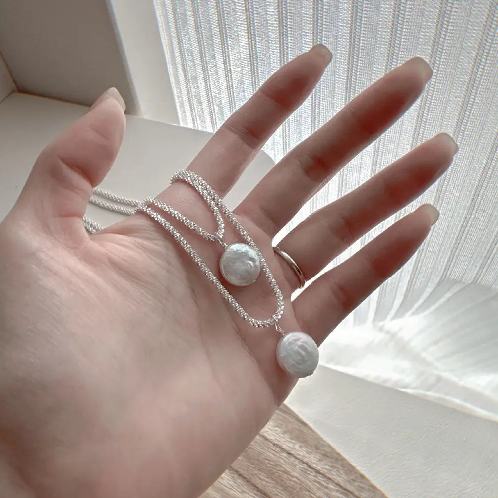 Sterling silver baroque pearl starry sky necklace with a delicate silver chain and two round white pearl pendants.