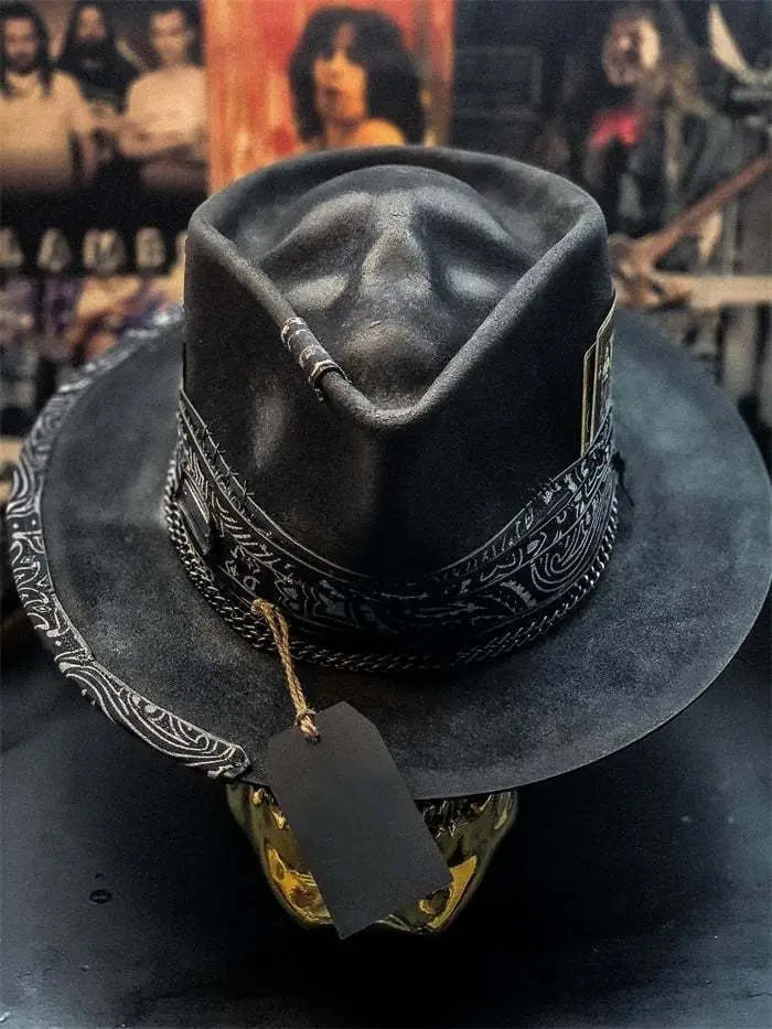 Black suede plush skull cowboy hat featuring an intricate silver-toned band with a decorative skull display.