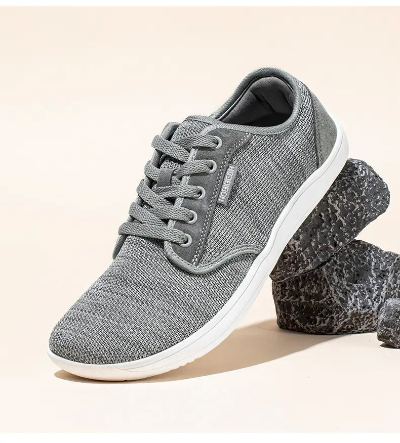 Chaussures de sport décontractées en daim unisexes gs6968 en toile tissée grise, semelle en caoutchouc blanche et lacets assortis, avec un discret marquage de marque sur le côté.