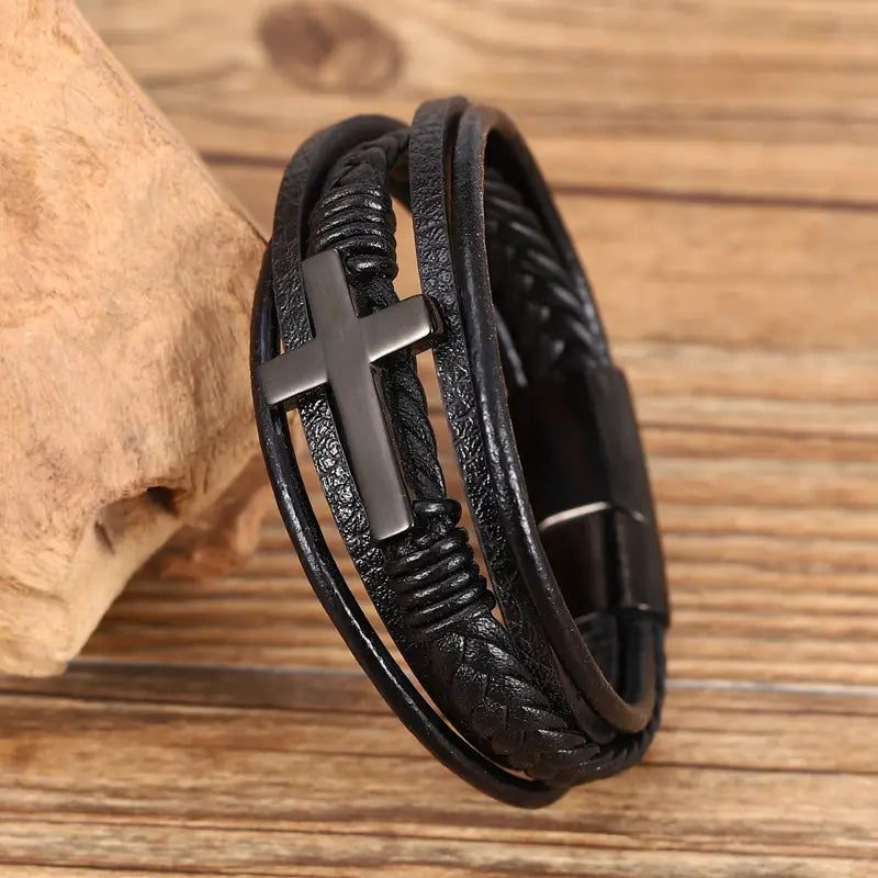 black leather braided multi-strand bracelet featuring a matte black cross pendant and a magnetic clasp.