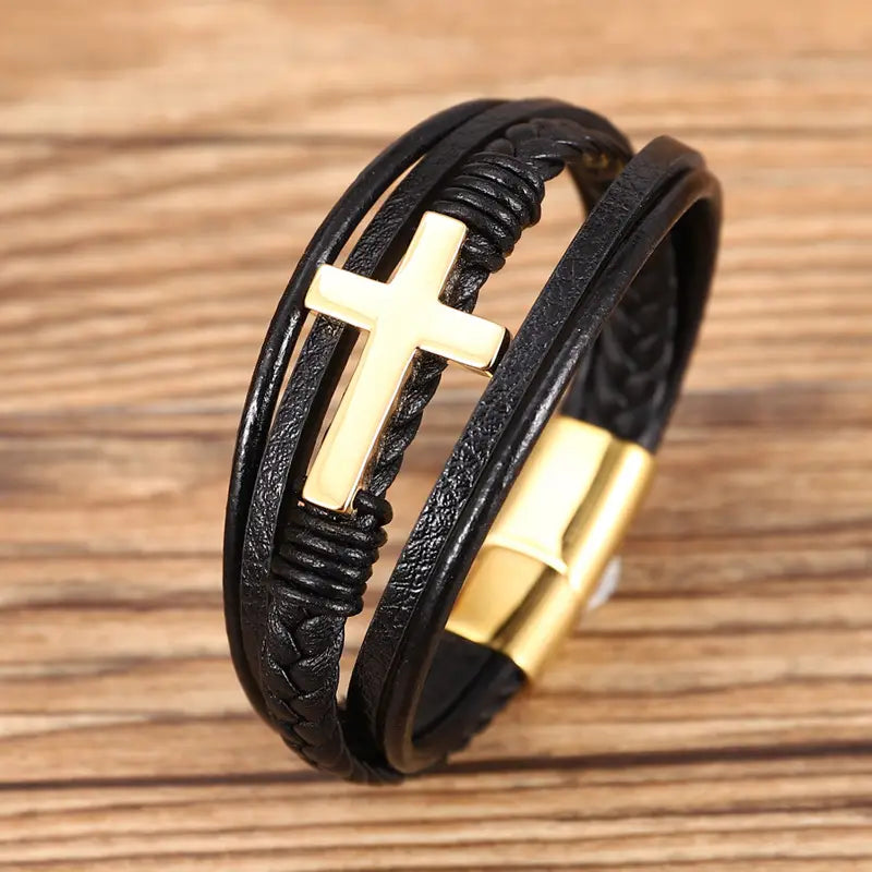 Black leather braided multi-strand cross bracelet featuring a gold-tone charm and a magnetic clasp.