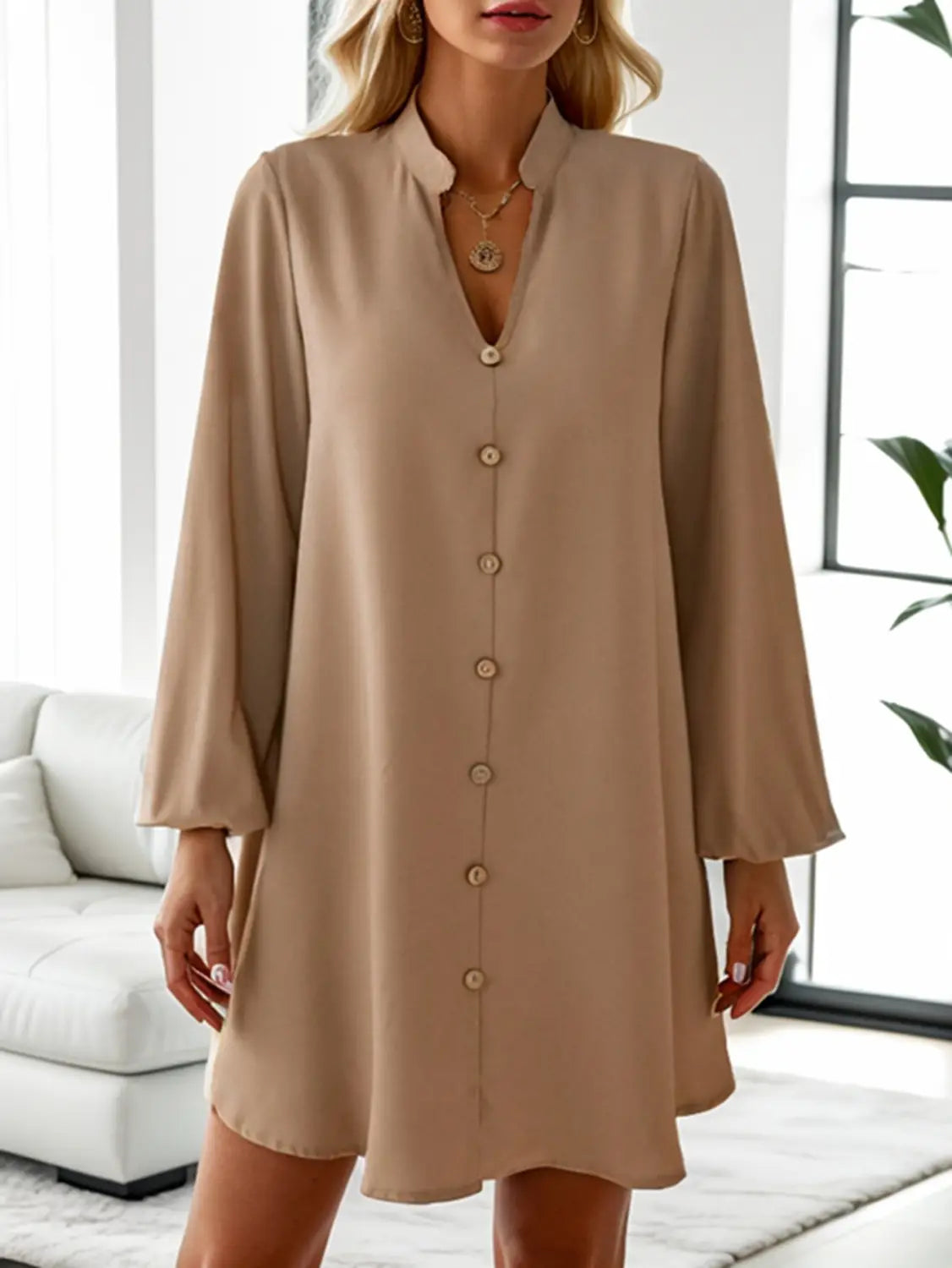 Beige bell sleeve button down midi dress with long sleeves flowing fabric and a v-neckline.