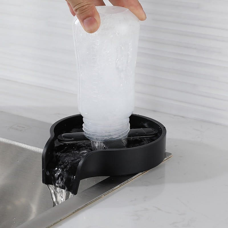 black plastic pet water fountain base with white translucent bottle being filled from above in the cup washer for kitchen sink automatic glass rinser.