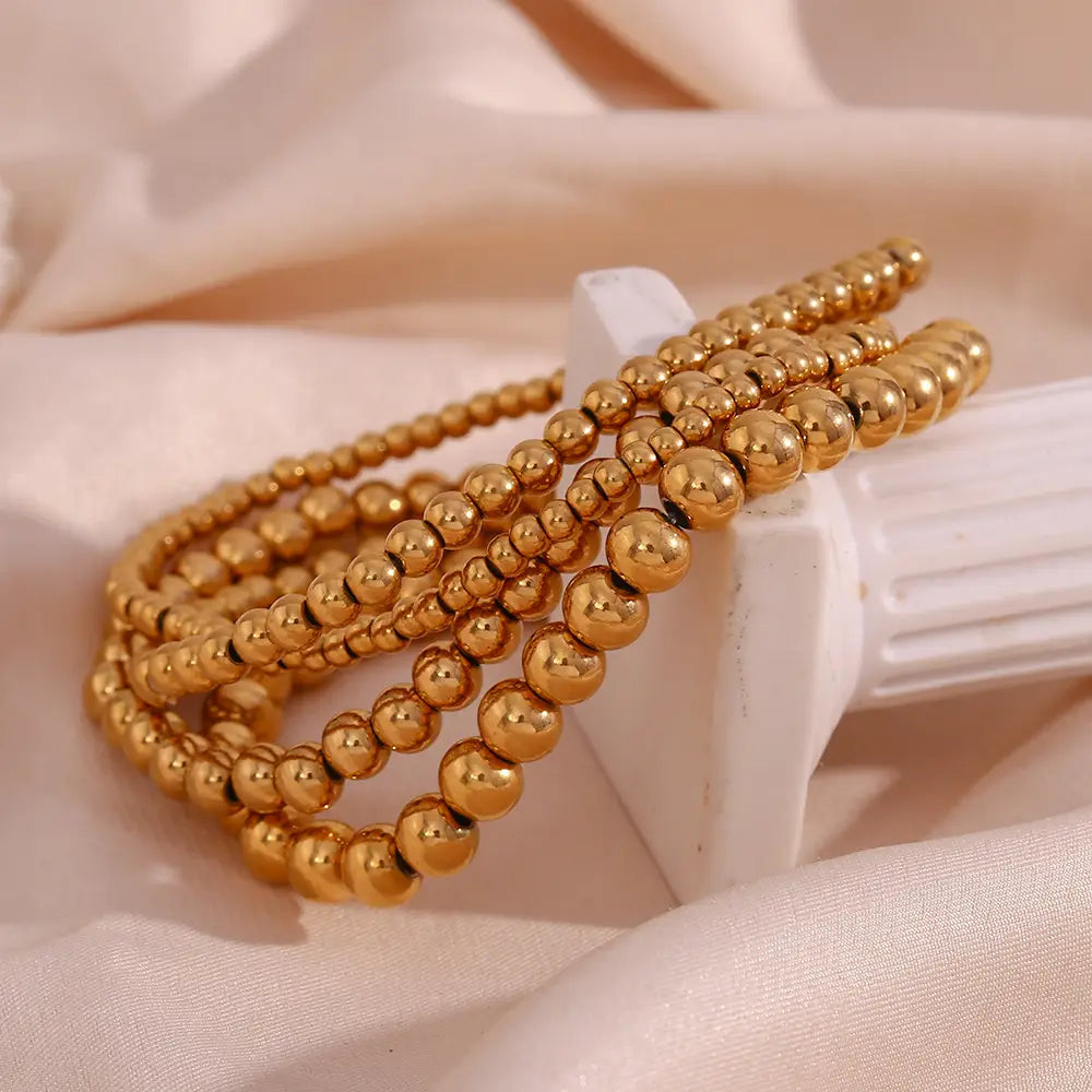 18k gold plated stainless steel elastic bead bracelet featuring a sleek golden beaded design.