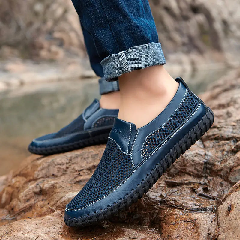 Mocassins à enfiler en mesh de cuir bleu foncé, dotés de panneaux respirants et de finitions cousues, avec une semelle en caoutchouc tressé.