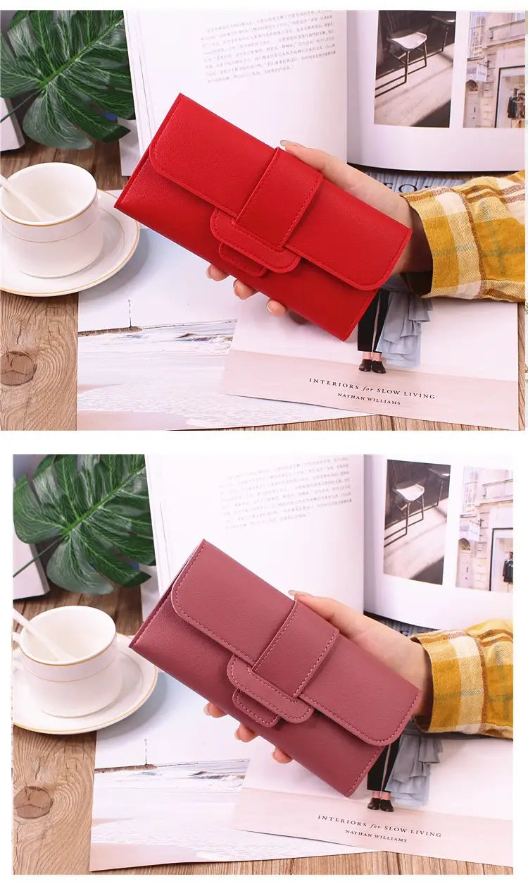 Women’s tri-fold leather clutch wallet in red and dusty rose with flap closure and stitched detailing.