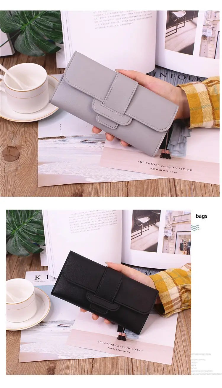 Gray and black leather women’s tri-fold clutch wallet with a flap closure and minimalist design featuring card slots