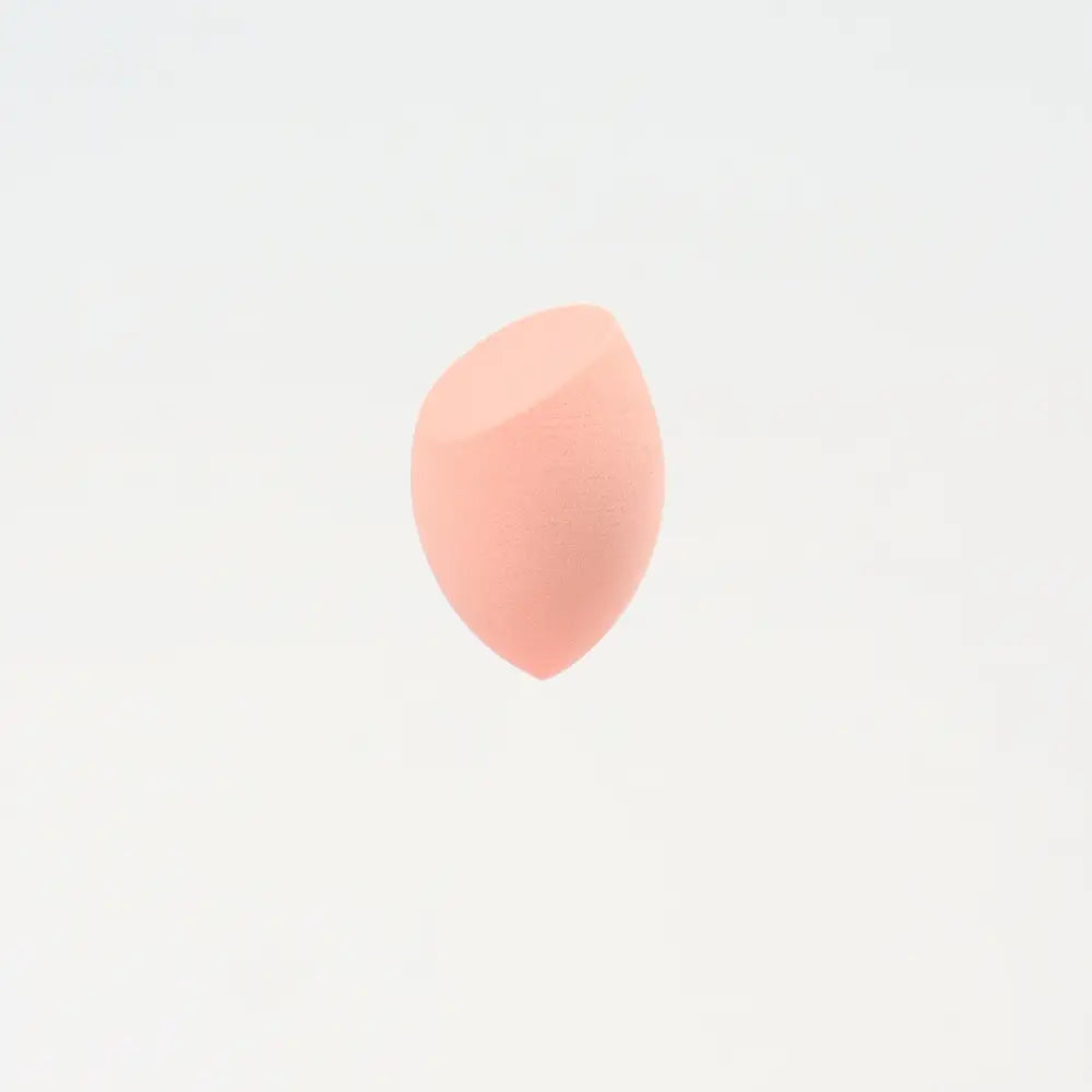 Une mini éponge de maquillage lilas pêche doux en forme de goutte, à surface lisse légèrement texturée, conçue pour estomper les produits de beauté.