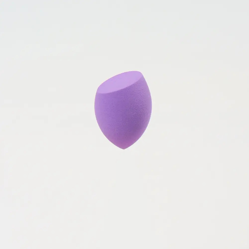 Une mini éponge de maquillage lilas doux, de forme goutte, à surface poreuse lisse, conçue pour estomper harmonieusement le maquillage.