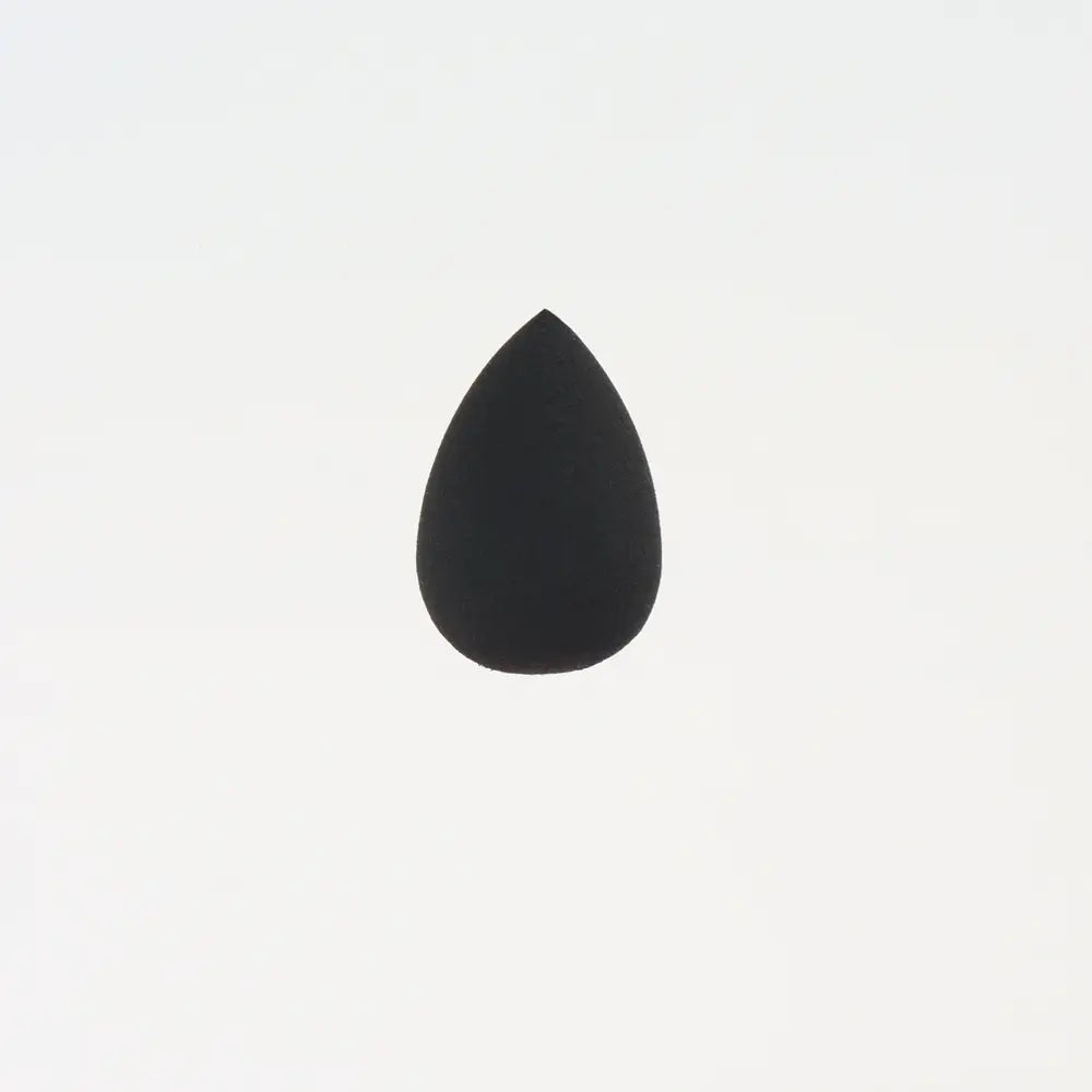 Une mini éponge de maquillage noire et douce en forme de goutte, fabriquée dans une matière de beauty blender, pour une application précise.