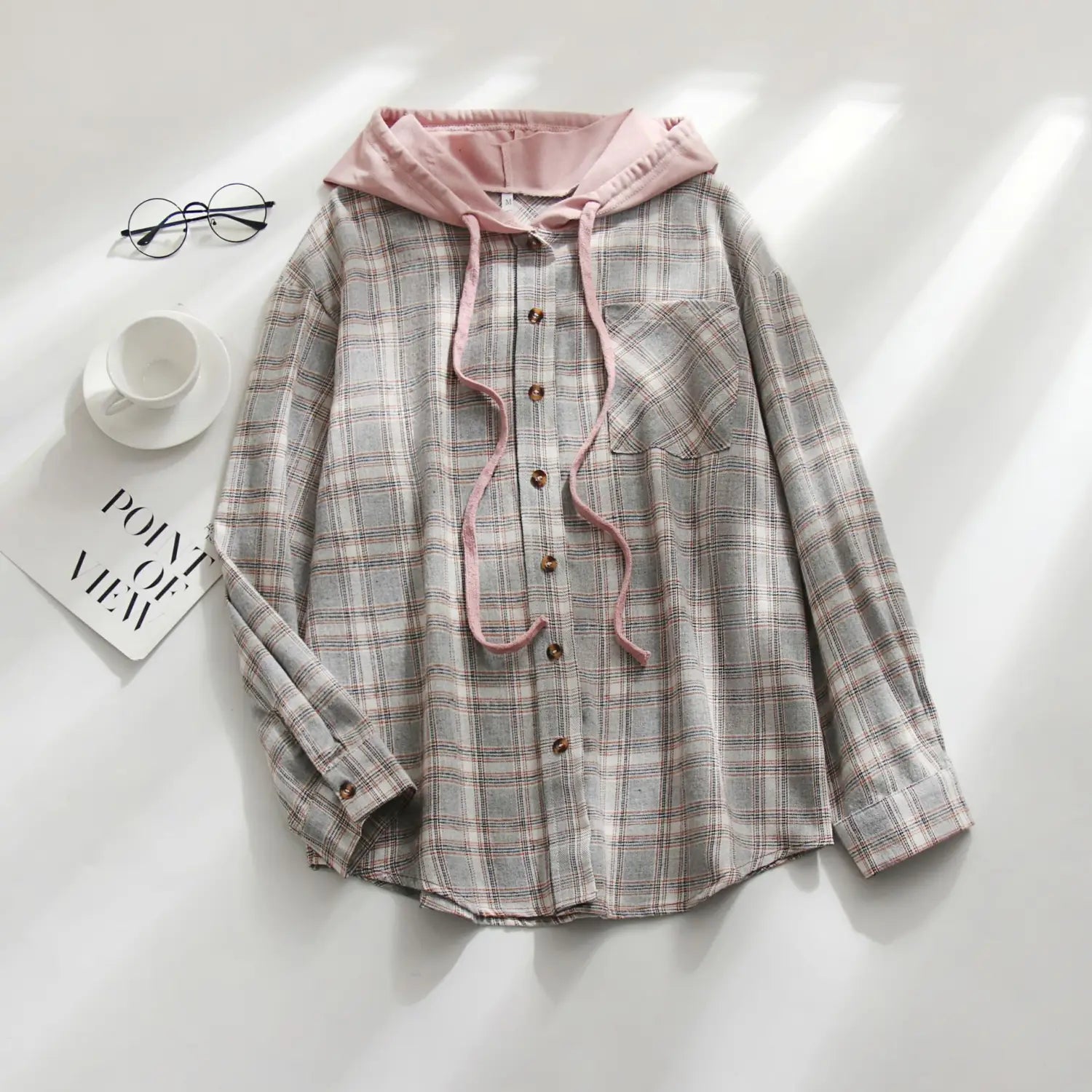 Women’s plaid long sleeve hooded button up shirt in soft gray and white plaid with a contrasting pink inner lining and drawstrings.