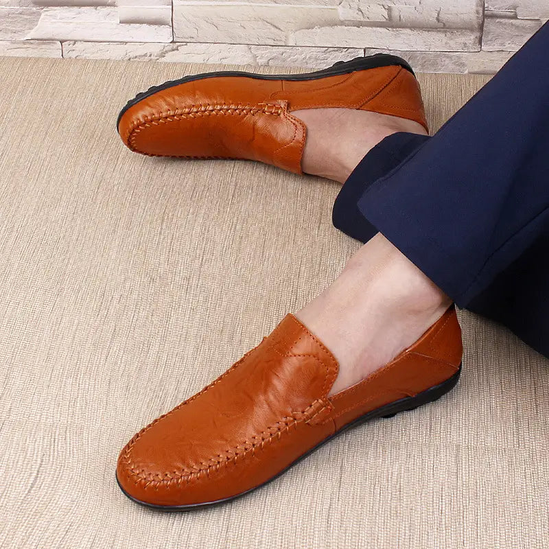 Mocasines sin cordones tipo loafer de cuero de badana color camel, transpirables, con perforaciones tipo gommino, con costuras visibles a lo largo de los bordes y suela de goma negra.