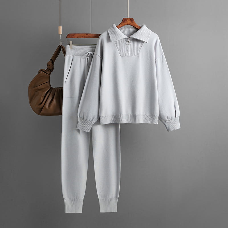 Conjunto de chándal de punto gris claro con detalle de cremallera frontal con cuello, puños y bajo acanalados.