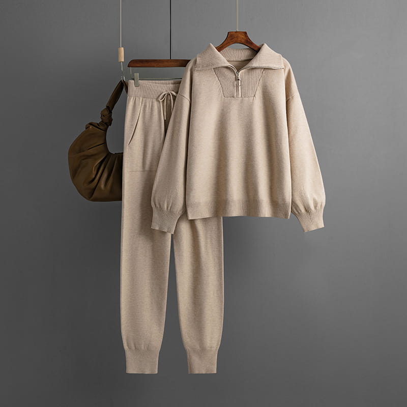 Conjunto de chándal de punto color beige de dos piezas, con detalle de cremallera en el cuello elaborado con tejido de punto suave.